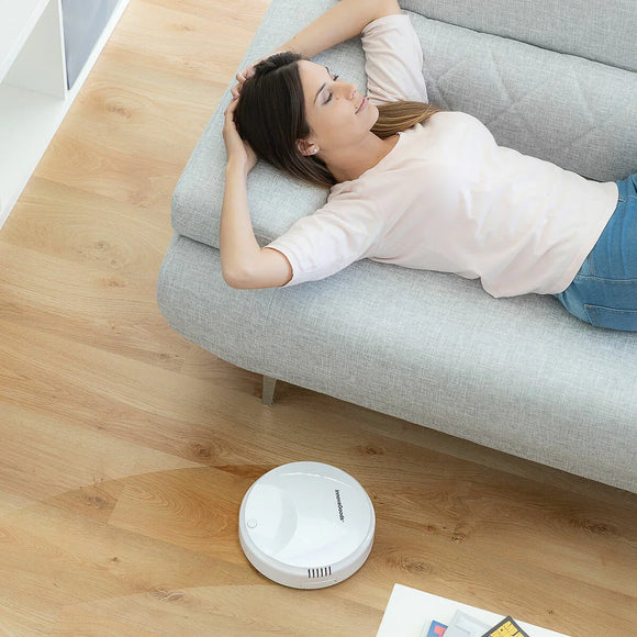 Robot aspirapolvere Smart con mappatura intelligente accanto a una persona rilassata sul divano
