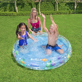 Bambini che giocano in una piscina gonfiabile bambini giardino con pesci colorati per divertirsi all'aperto