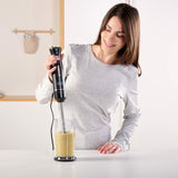 Donna che utilizza un frullatore a immersione Black & Decker per preparare frullati in cucina
