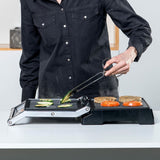 Piastra grill elettrica Black & Decker in uso, con verdure e hamburger grigliati su una superficie antiaderente