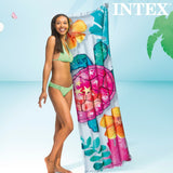 Donna sorridente con un materassino gonfiabile Intex tropicale con motivo colorato di tartaruga e fiori