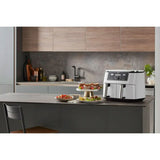 Friggitrice ad aria Ninja grande capacità in cucina moderna con piatti di cibo fresco sul tavolo