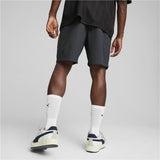 Pantaloncini sportivi uomo AC Milan Puma grigi indossati da un atleta con scarpe sportive