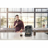 Caffettiera automatica Philips EP1224 in cucina con persona che beve caffè e chicchi di caffè sul tavolo