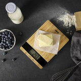 Bilancia da cucina digitale Princess su superficie di legno con burro, farina e mirtilli