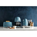 Caffettiera americana Smeg in blu con tostapane e bollitore su un elegante piano di lavoro