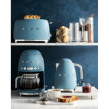 Caffettiera americana Smeg in azzurro con tostapane e bollitore su un ripiano di cucina elegante