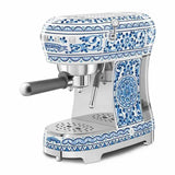 Caffettiera Smeg express a leva con decorazioni blu e bianche, perfetta per preparare caffè espresso di qualità