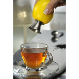 Spremiagrumi Gefu Citronello in uso, spremendo un limone sopra una tazza di tè caldo